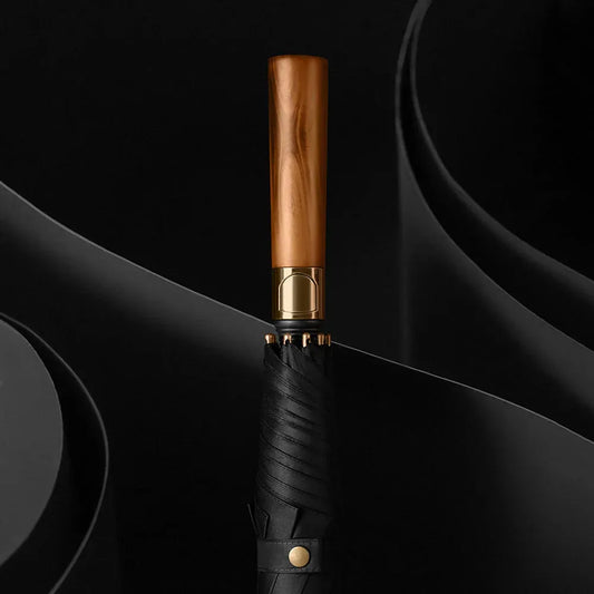 Detailed close-up of the closed black long umbrella, focusing on the natural straight wood handle.