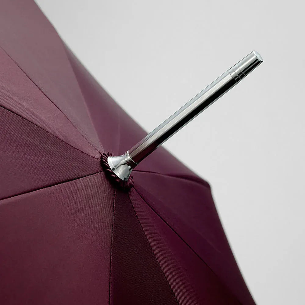 Close-up detail of the silver top ferrule on the open burgundy canopy.