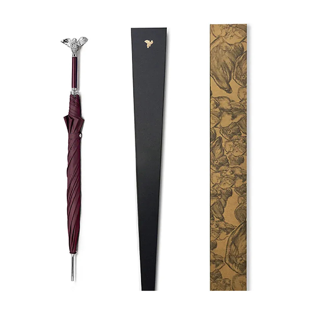 The closed burgundy angel handle umbrella shown alongside its elegant black and patterned packaging.