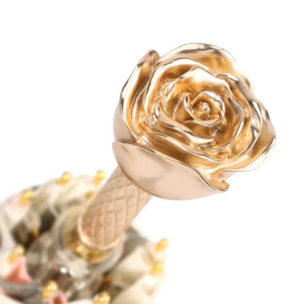 Detailed close-up of the exquisitely sculpted golden rose flower handle.