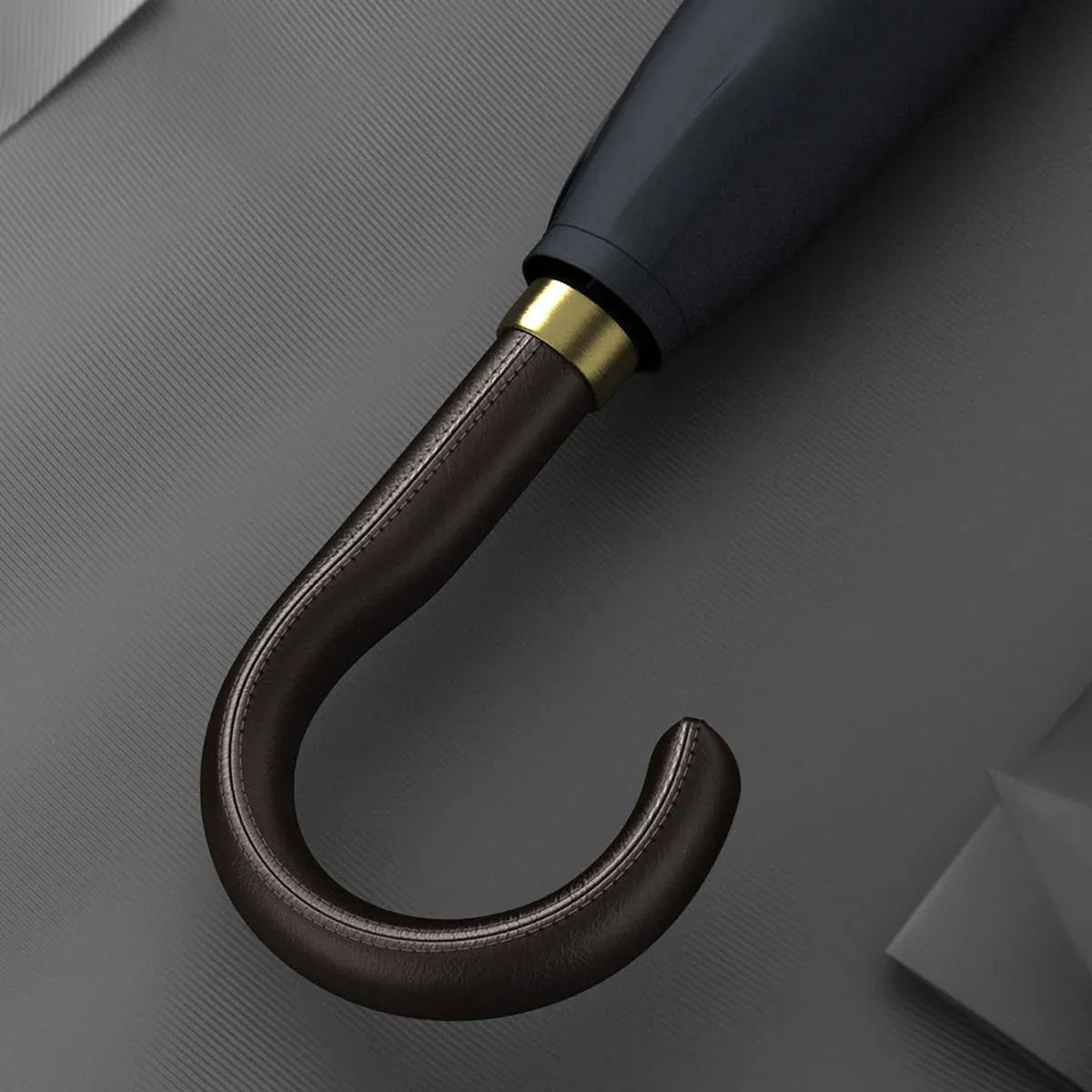 Detailed close-up of the stitched brown leather crook handle with gold accents.