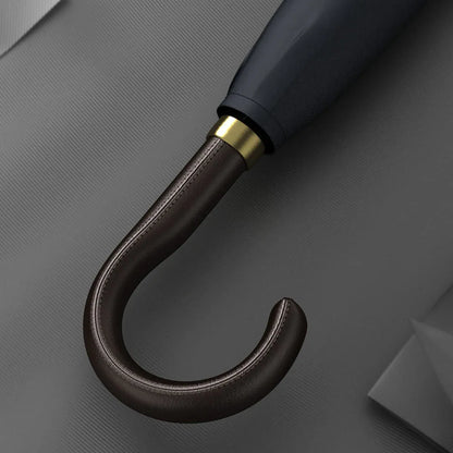 Detailed close-up of the stitched brown leather crook handle with gold accents.