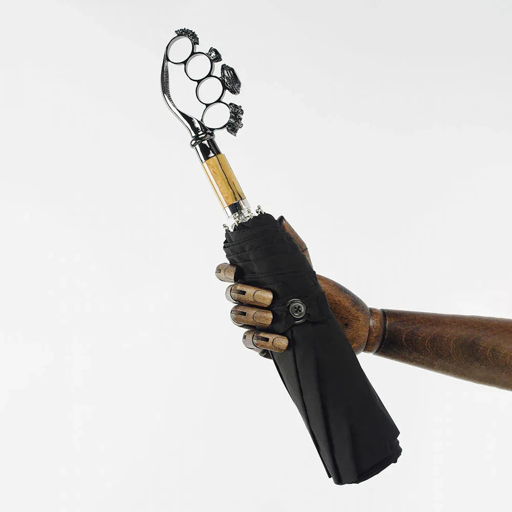 A wooden mannequin hand holding the closed luxury ring handle umbrella, showing its scale.