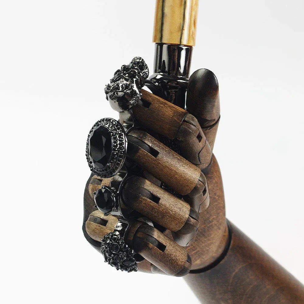Close-up showing the jeweled gothic ring handle being held by a wooden mannequin hand.