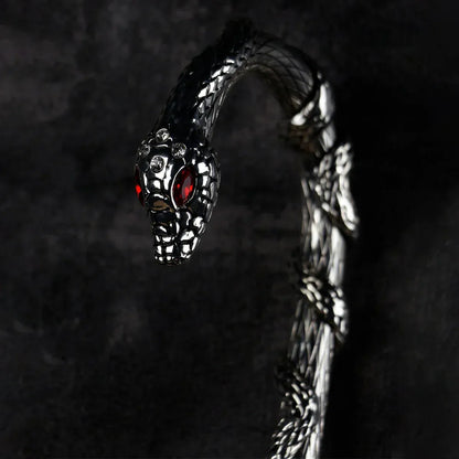 Detailed close-up of the sculpted silver snake handle with red crystal eyes, on the serpent pattern umbrella.