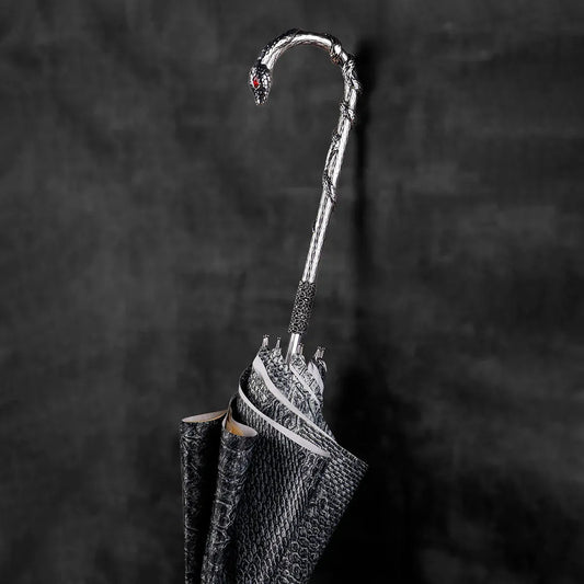 Extreme close-up of the silver snake head handle, showing the intricate scales and red crystal eyes.