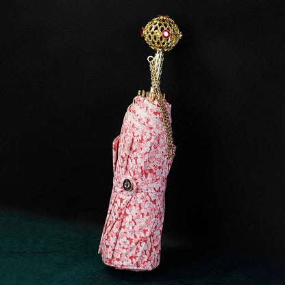 Elegant Pink Floral Umbrella with luxury gold handle, stylish accessory for women.