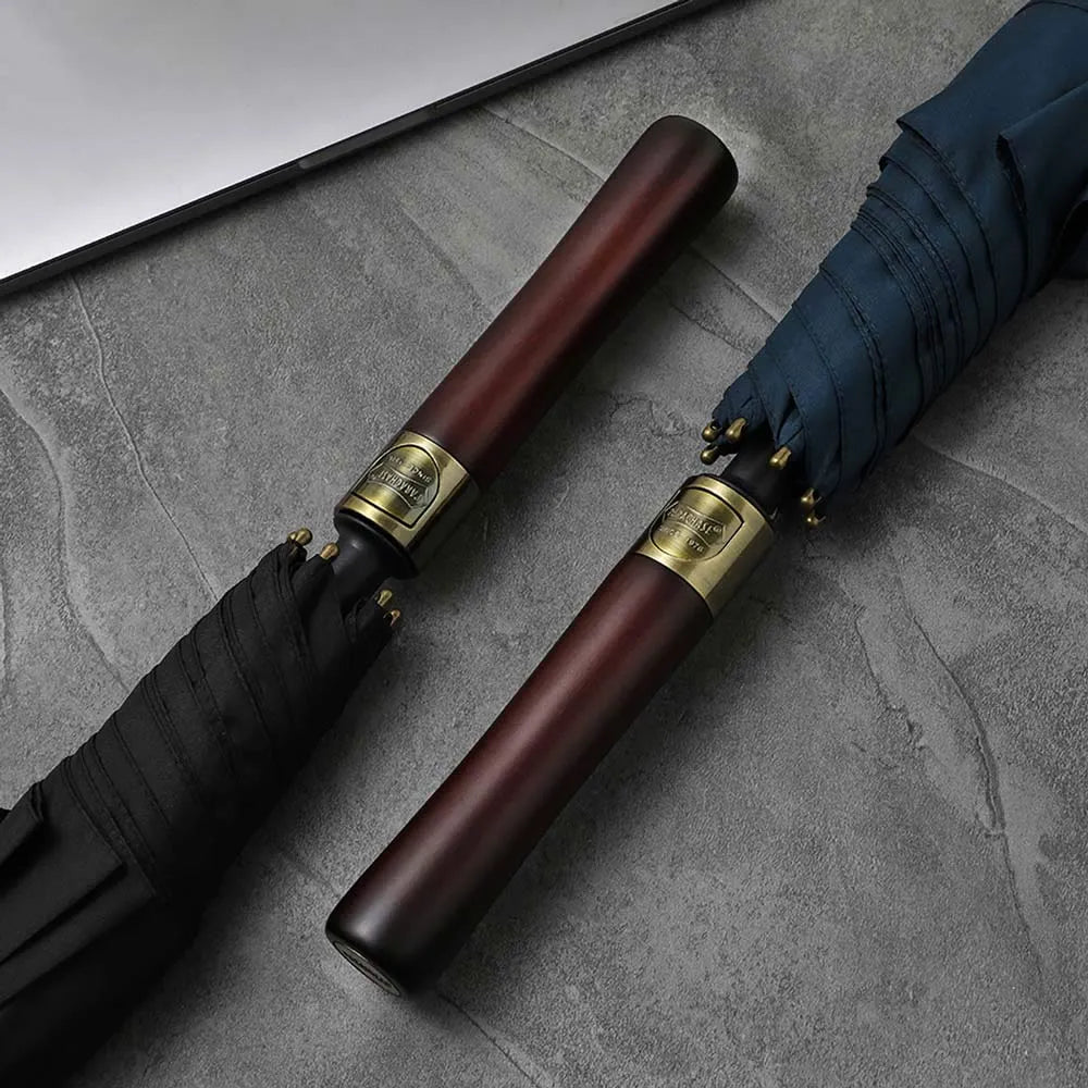 Close-up showing the detail and wood grain of the straight handles on the black and navy umbrellas.
