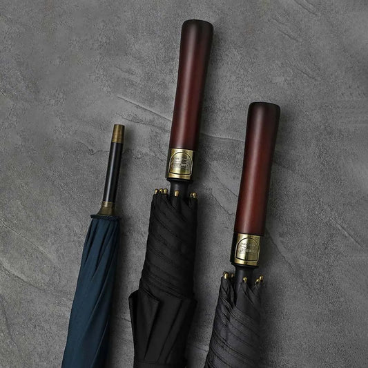 Lifestyle arrangement showing the straight wood handles of the premium umbrellas in black and navy.