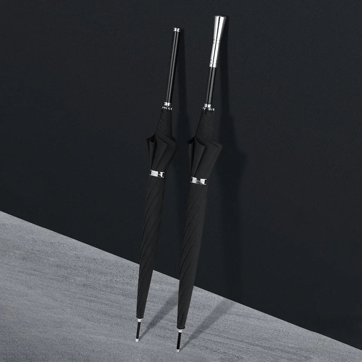 Two closed premium long handle umbrellas, one with an alloy handle and one with a dark wooden handle.