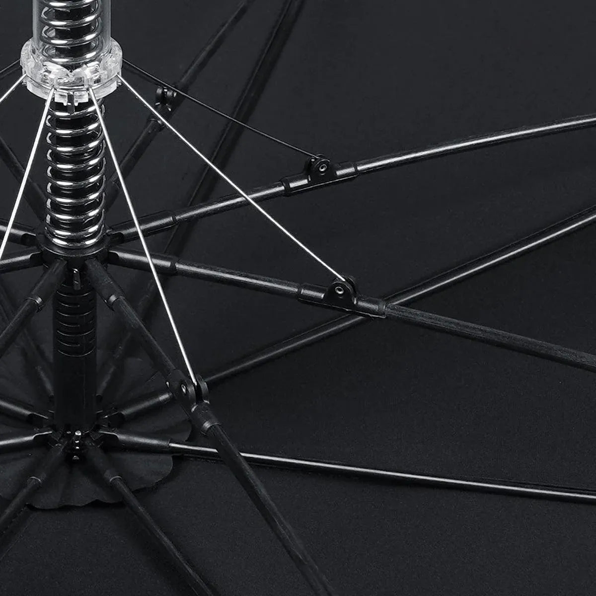 View from underneath the open black canopy showing the 8-rib fiberglass frame and central spring mechanism.