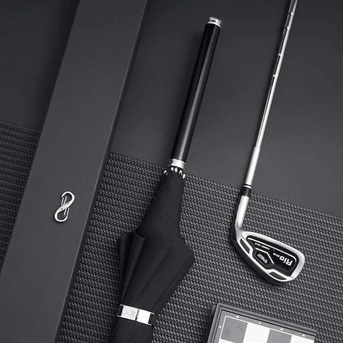 Lifestyle image showing the closed premium long handle umbrella with a dark wooden handle next to a golf club.