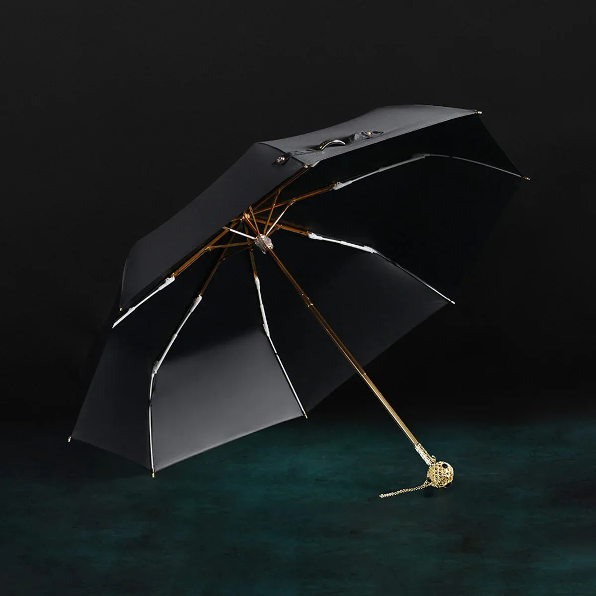 The open black Prestige folding umbrella with its crystal-embellished gold handle, showcasing the black interior lining.