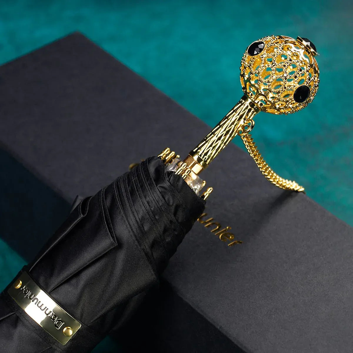 The Prestige crystal handle folding umbrella for women in black, showing the ornate gold handle with black crystals.