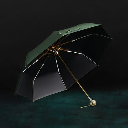 The open green Prestige folding umbrella with its crystal-embellished gold handle, showcasing the black interior lining.