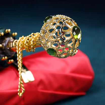 Another close-up angle of the ornate gold handle with green crystals on the Prestige umbrella.