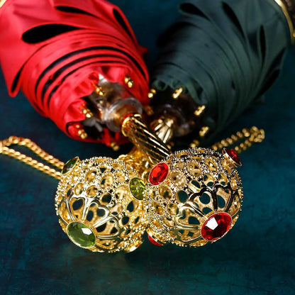 Close-up of the ornate gold handles for the red and green Prestige umbrellas, showing crystal details.