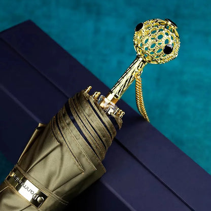 The Prestige crystal handle folding umbrella for women in olive, showing the ornate gold handle with black crystals.