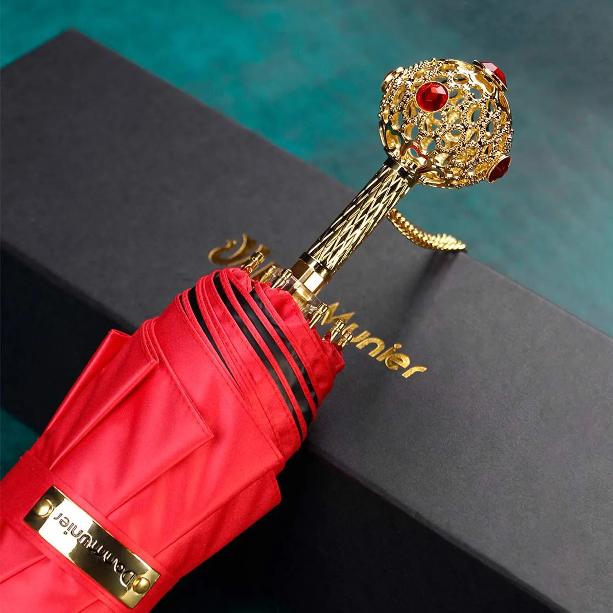 The Prestige crystal handle folding umbrella for women in red, showing the ornate gold handle with red crystals.
