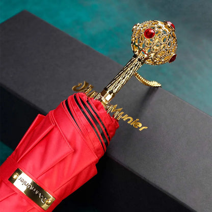 The Prestige crystal handle folding umbrella for women in red, showing the ornate gold handle with red crystals.