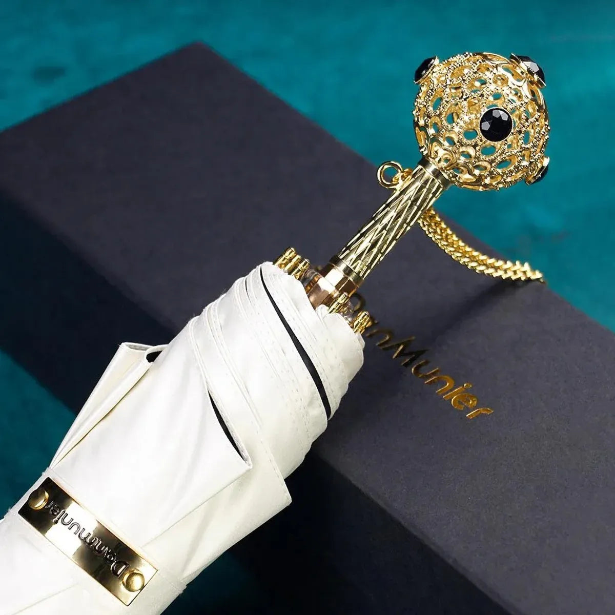 The Prestige crystal handle folding umbrella for women in white, showing the ornate gold handle with black crystals.