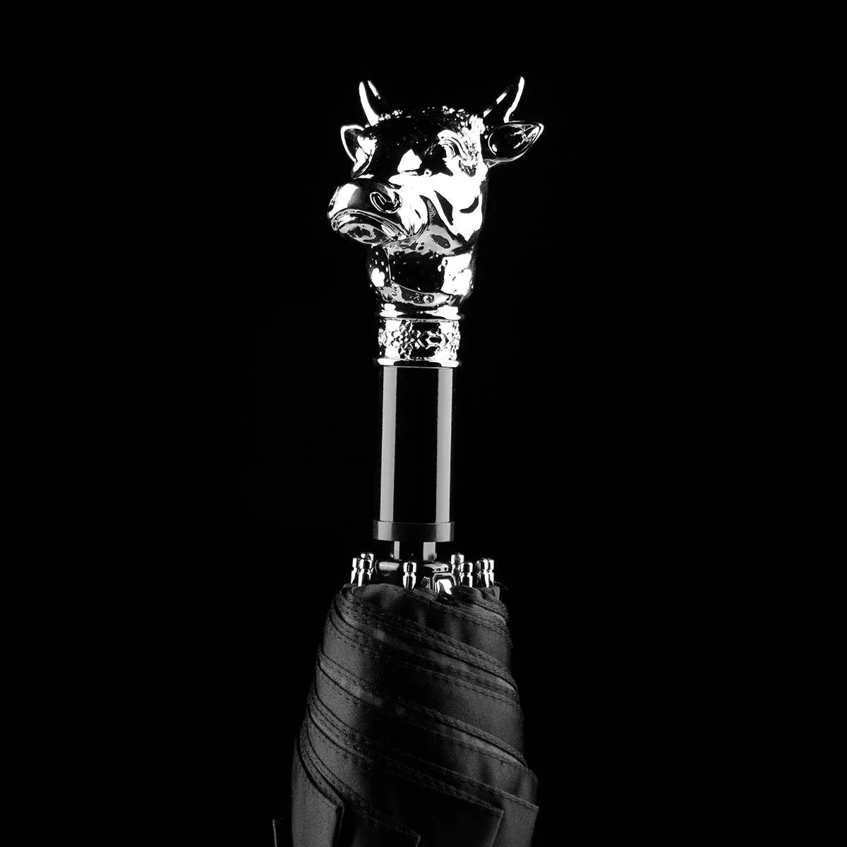 The silver animal head folding umbrella featuring the intricately detailed Bull handle against a black background.