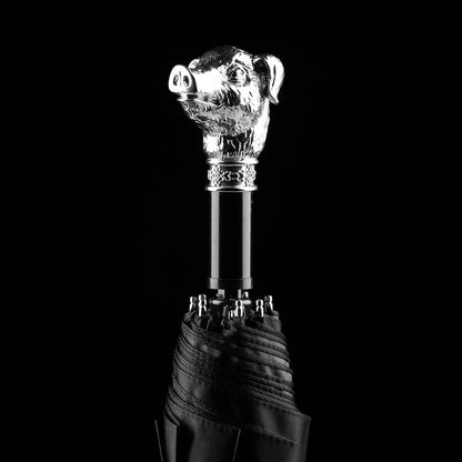 The silver animal head folding umbrella featuring the intricately detailed Pig handle against a black background.