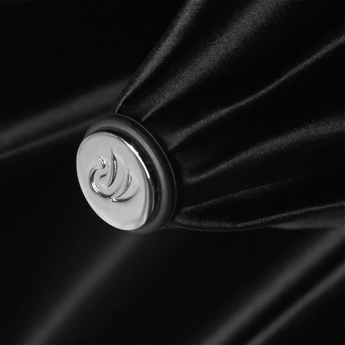 Close-up detail of the silver bottom end cap on the closed cobra head umbrella.