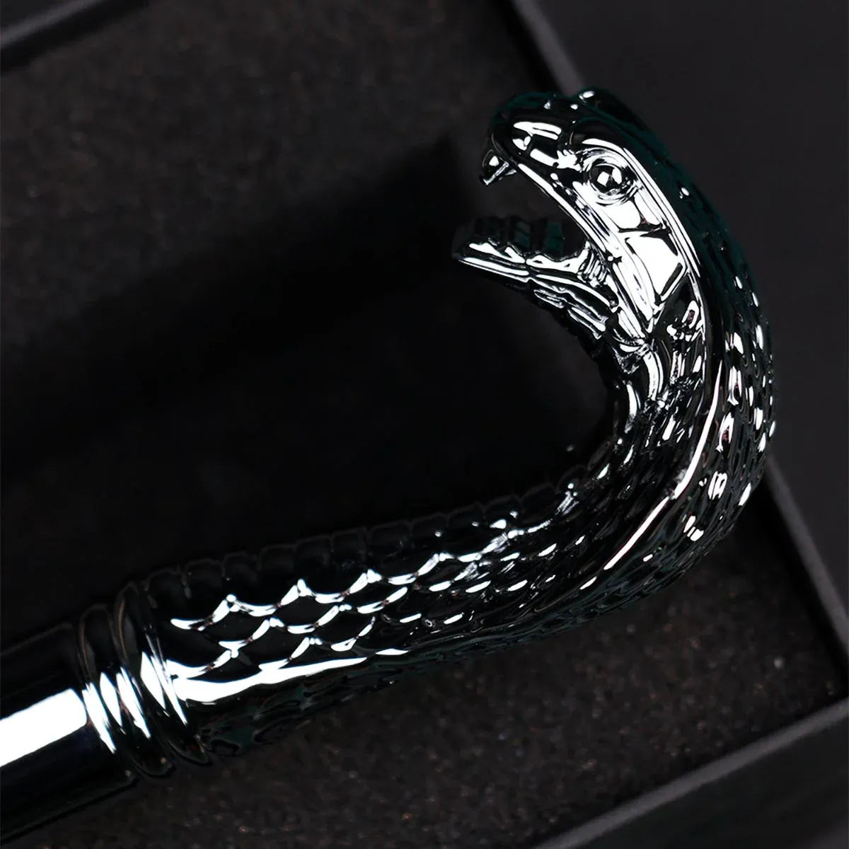 Detailed close-up of the polished silver cobra head handle showcasing the intricate scale texture.