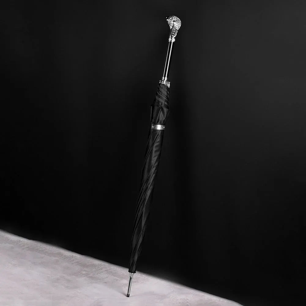 The silver cobra head luxury parasol standing closed against a dark background.