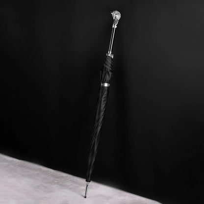 The silver cobra head luxury parasol standing closed against a dark background.