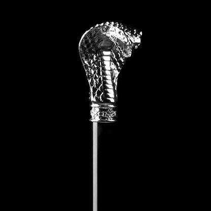 Dramatic close-up of the sculpted silver cobra head handle against a pure black background.