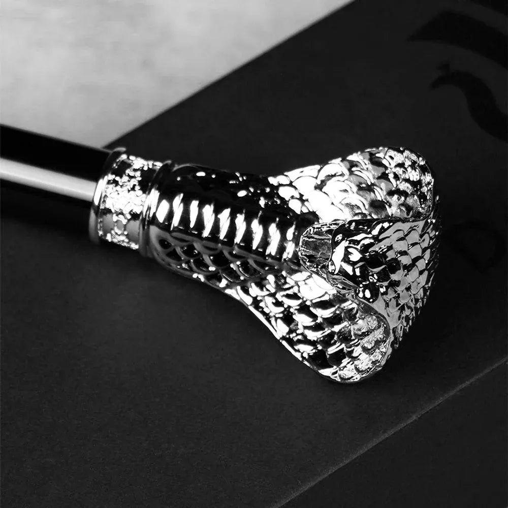 Top-down close-up view of the detailed silver cobra head handle resting on a dark surface.